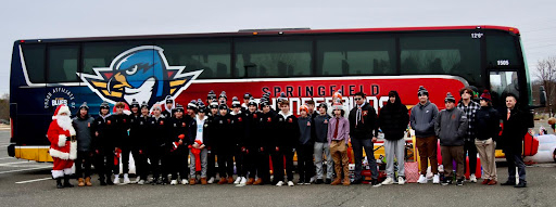 AHS Hockey players in front of the Thunderbirds' bus