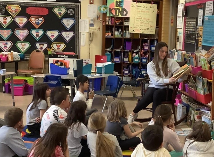 Gabby Z reading to an elementary class